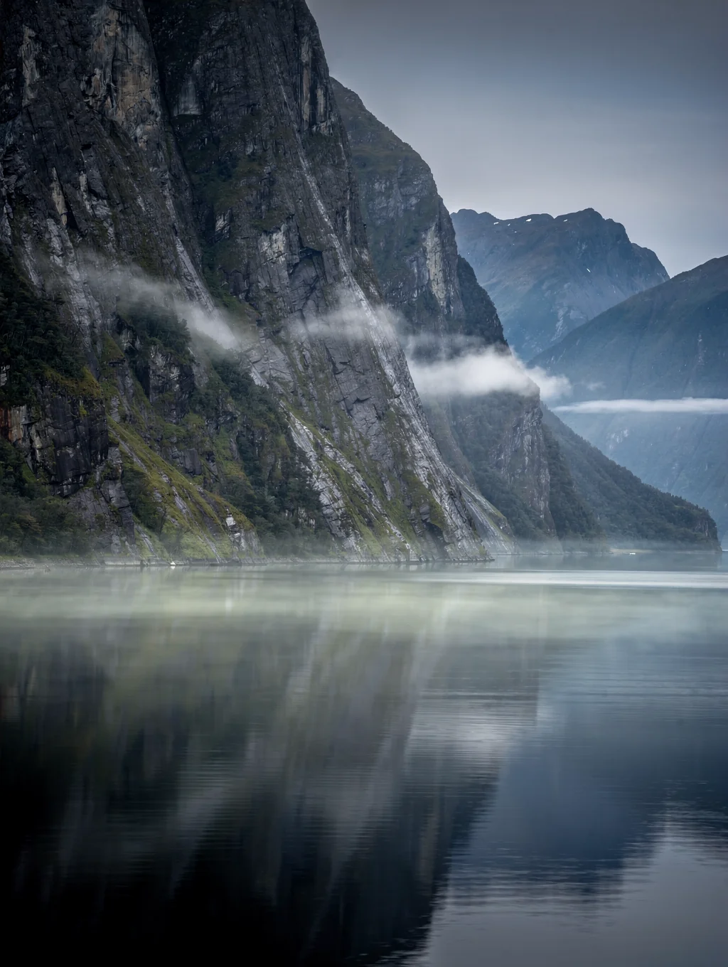 Mitre Peak rising over tranquil waters and fiord mist in New Zealand